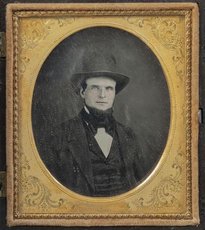 Sixth Plate Daguerreotype of a Fireman Seated with Tall Hat. The dag has its original gutta-percha case with raised image of a standing fireman.